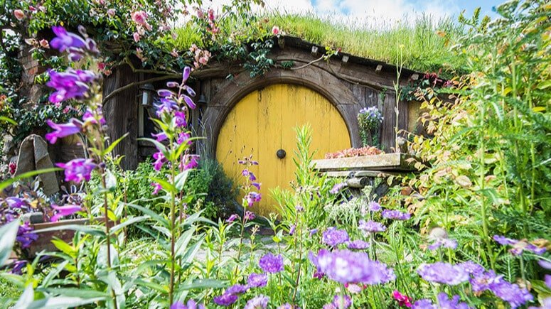 Detailed close-up of Hobbiton movie set showing quaint hobbit door and garden features