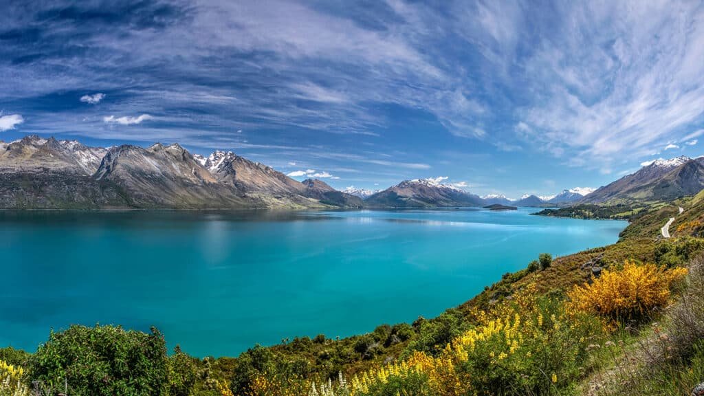 Panoramic view of Lake Wakatipu with crystal-clear water and mountain backdrop
