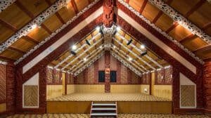 Traditional Māori marae interior with intricate carvings and woven panels at Te Puia