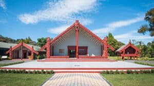 Exterior view of a traditional Māori marae building at Te Puia with carved wooden panels and meeting house