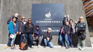 Visitors gathered around educational glowworm signage at the Waitomo Glowworm Caves tour centre