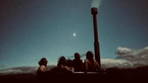 Guests relaxing in a wood-fired hot tub under the stars at Blackburn Ridge Rural Retreat