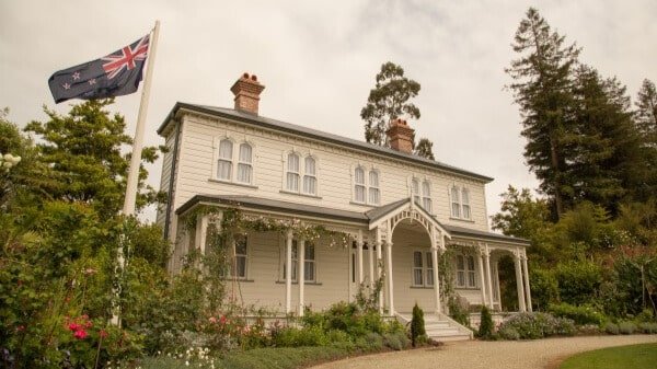 Historic building and flagstaff flying the New Zealand flag in Mansfield Garden, Hamilton Gardens