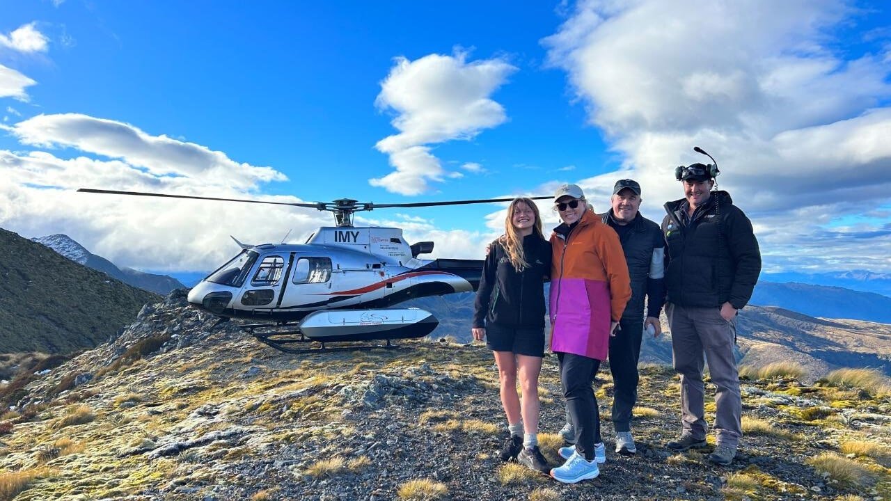 Helicopter landed on alpine peak near Milford Sound with panoramic views