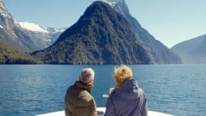 Boat cruising in Milford Sound with Mitre Peak in the background