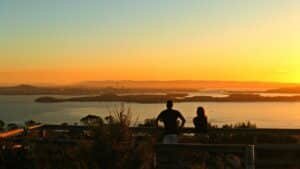 Sunset over Rangitoto Island with Auckland City skyline and Sky Tower in the background