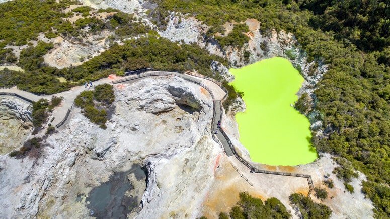 Aerial view of a bright green geothermal pond at Wai-O-Tapu in Rotorua