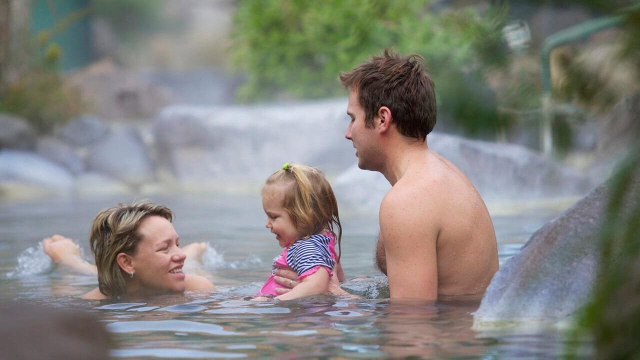 Family relaxing together in geothermal pools at Rotorua’s Polynesian Spa