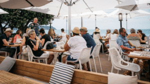 Guests seated outdoors enjoying lunch under sun umbrellas on Waiheke Island wine tour