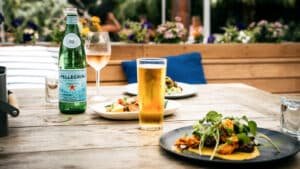 Chilled beer and wine glasses sweating on the table beside a delicious food spread on Waiheke Island