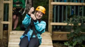 Happy person smiling while ziplining over lush native bush in Coromandel