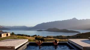 View from the spa pool overlooking a tranquil lake surrounded by majestic mountains at Aroha Wellness Retreat.