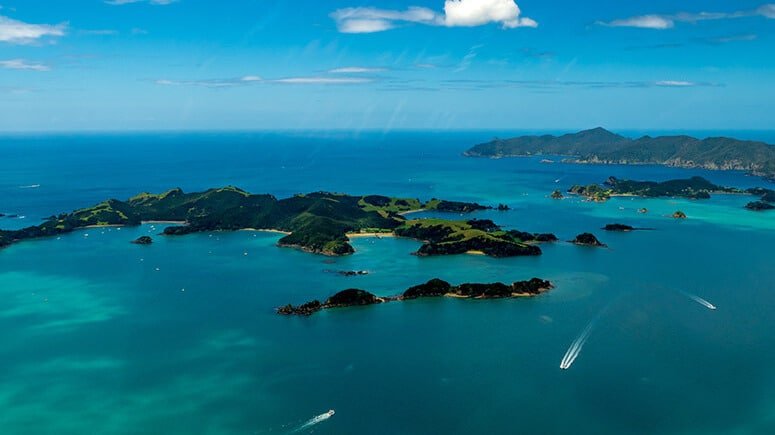 Aerial view of the Bay of Islands with boats cruising through the sparkling blue waters.
