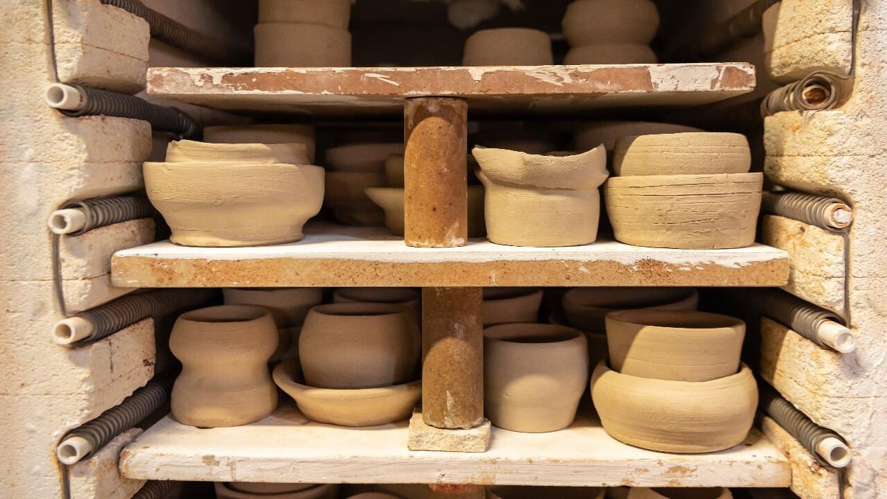 Full kiln filled with pottery pieces drying after class at Driving Creek pottery workshop.