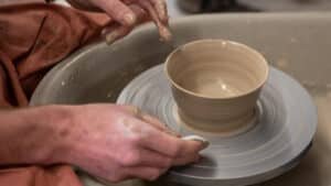 Clay bowl beginning to form on a spinning pottery wheel during a wheel-throwing class at Driving Creek.