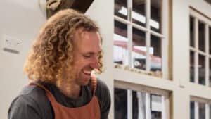 Person smiling and happily making pottery during a fun class at Driving Creek, Coromandel.