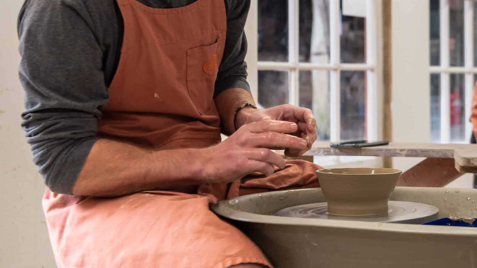 Close-up of a spinning pottery wheel shaping a clay bowl during a pottery technique class at Driving Creek.