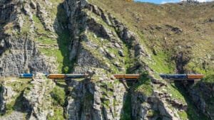 Taieri Gorge train winding along rocky mountain cliffs with scenic valley views