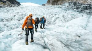 Adventurers ice tramping on Fox Glacier during a guided mountaineering tour.
