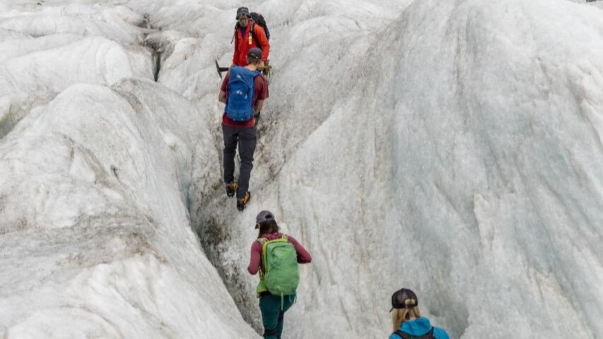 Group of hikers tramping across ice and snow on a helihike tour of Tasman Glacier from Queenstown