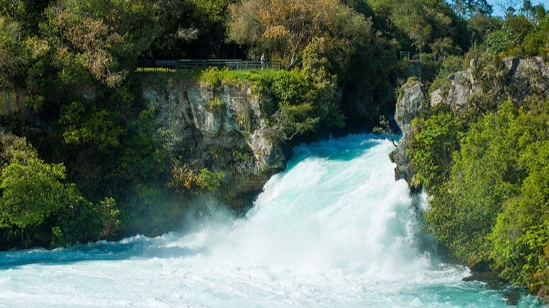 Powerful turquoise water rushing over Huka Falls waterfall in New Zealand