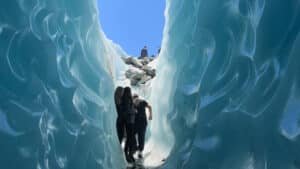 Small group walking through stunning blue ice caves on a helihike to Tasman Glacier from Queenstown