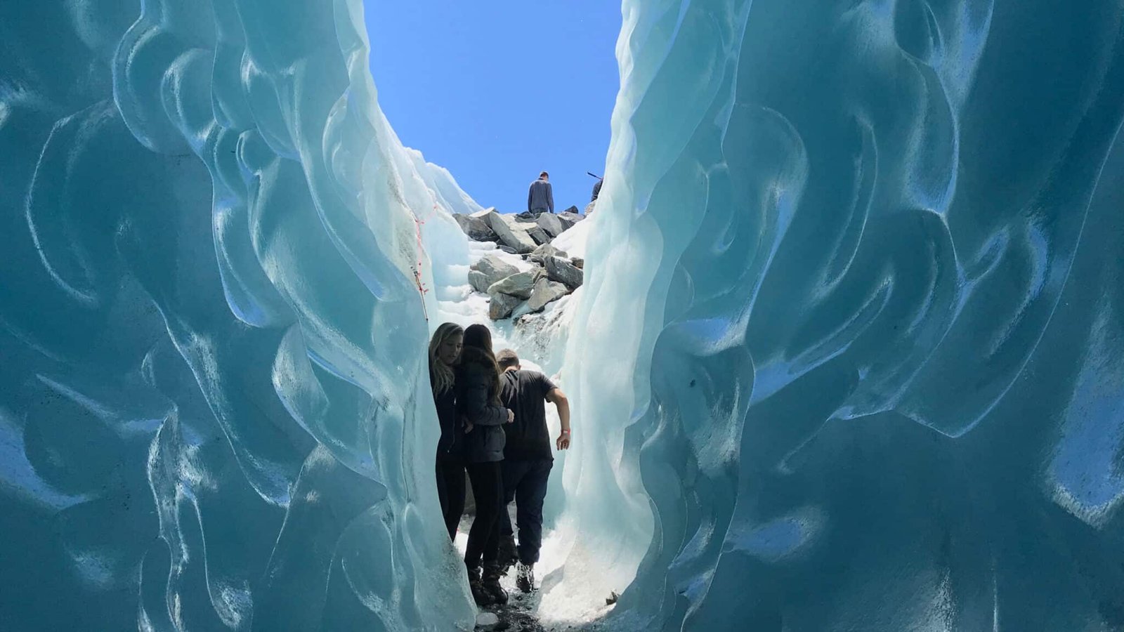 Small group walking through stunning blue ice caves on a helihike to Tasman Glacier from Queenstown