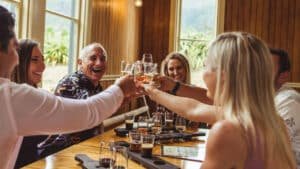 Group of friends raising glasses and cheering during a Queenstown twilight wine and craft beer tour