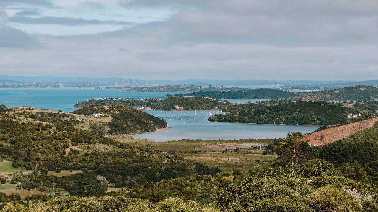 Boats anchored in a calm bay surrounded by lush hills on Waiheke Island