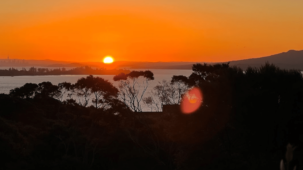 Vivid red and orange sunset sky over Waiheke Island vineyards