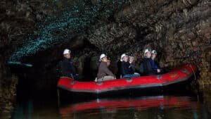 Small group on a raft entering the illuminated Waitomo Glow Worm Caves in New Zealand