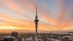 Auckland Sky Tower silhouetted against an orange-red sunset sky during a small group city tour