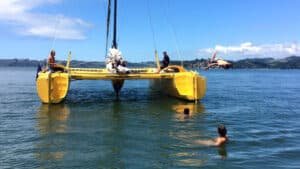 People swimming and jumping off a catamaran in the Coromandel bays from Flaxmill Bay