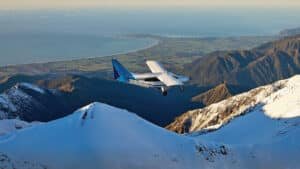 Small plane flying over snowy mountains near Kaikōura on a whale-watching tour