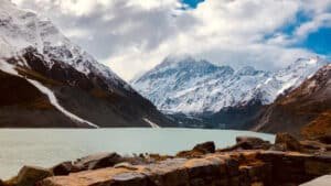 View over a pristine lake with snow-capped Mount Cook mountains in the background on a day tour from Christchurch via Tekapo