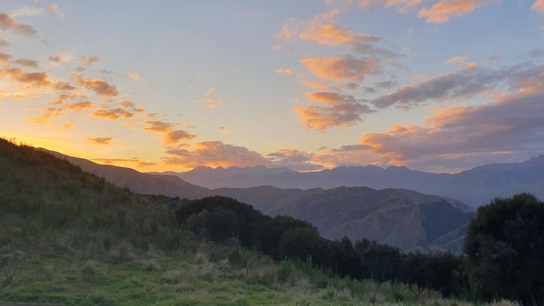Distant rolling mountain landscapes under a starry night sky during the Kaikōura Star Flight Zipline tour