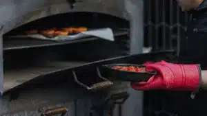 Hot pot dish emerging from wood-fired oven at Maruia River Retreat