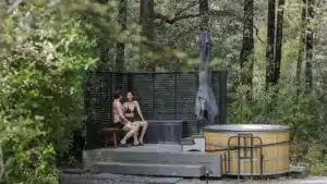 Couple relaxing in a forest hot tub at Maruia River Retreat