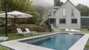 Magnesium pool with poolside loungers and umbrella at Maruia River Retreat