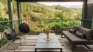 Outdoor seating area with coffee table surrounded by lush bush at Maruia River Retreat