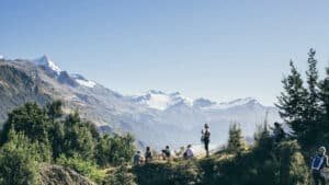 Guests resting at a mountain summit with panoramic alpine ranges near Aro Hā Wellness Retreat, New Zealand