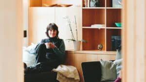 Guest relaxing with a hot drink in a cosy lounge with a friend at Aro Hā Wellness Retreat, New Zealand
