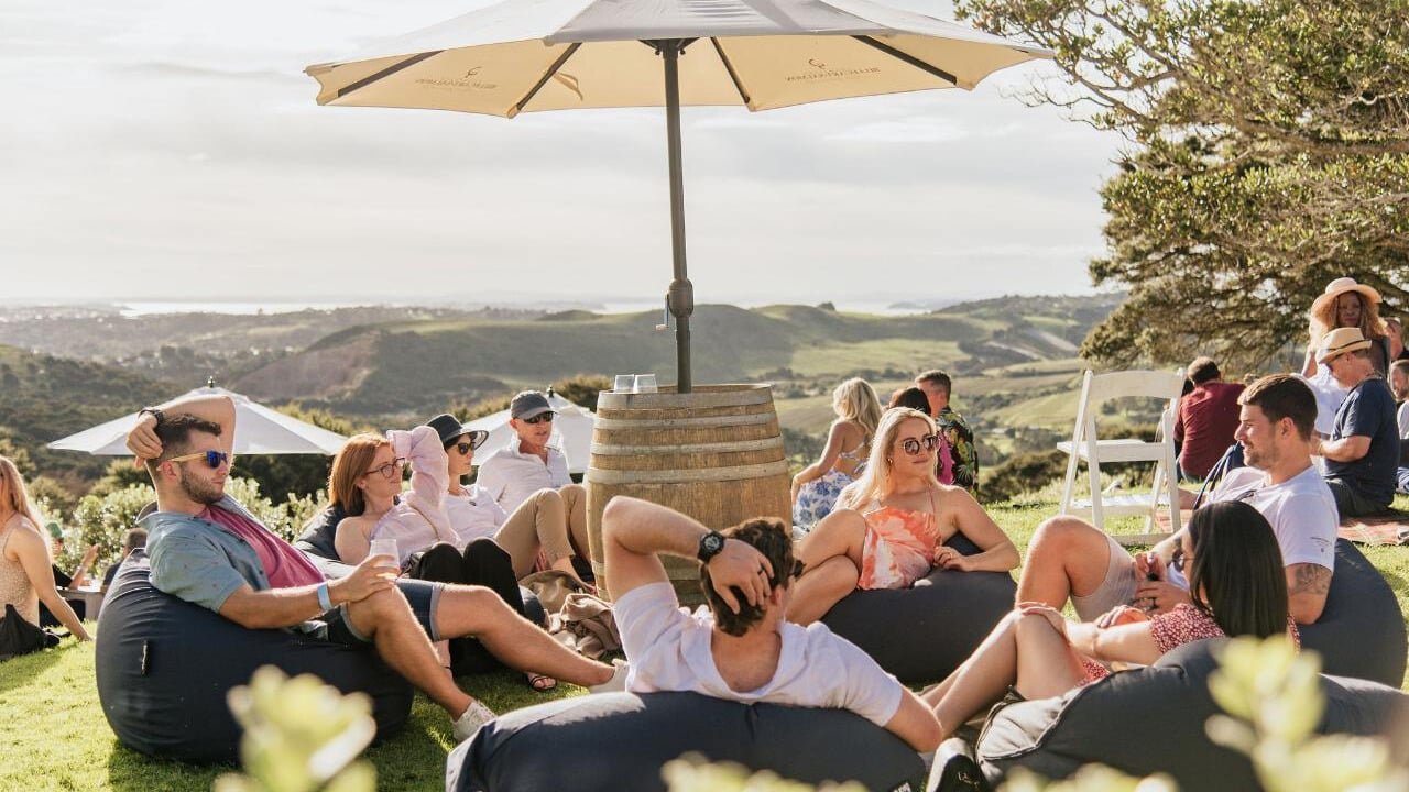 Group relaxing on bean bags under a sun umbrella on a sunny lawn
